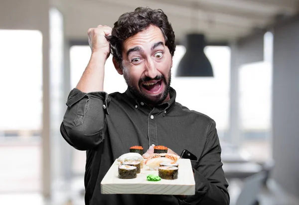 Mann isst Sushi in schockierter Pose — Stockfoto