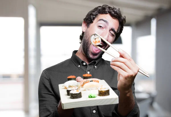Νεαρός άνδρας τρώει σούσι — Φωτογραφία Αρχείου