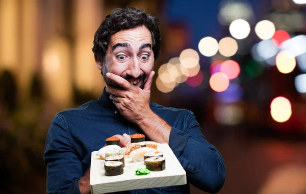 Junger Mann isst Sushi — Stockfoto
