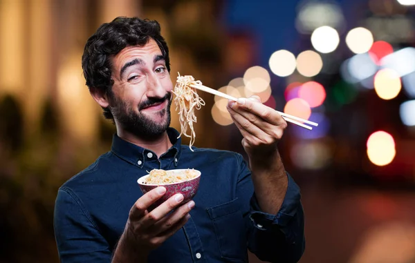 Человек ест суши из горшка с лапшой — стоковое фото