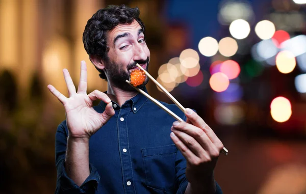 man eating sushi with all right sign