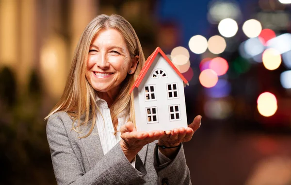 Senior beautiful woman with a house model — Stock Photo, Image