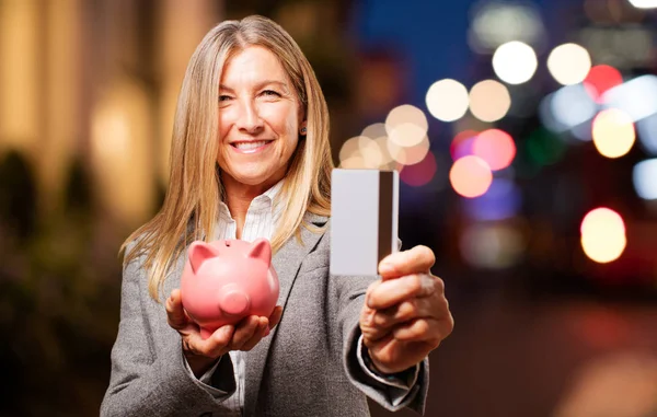 Mujer con alcancía y tarjeta de crédito — Foto de Stock