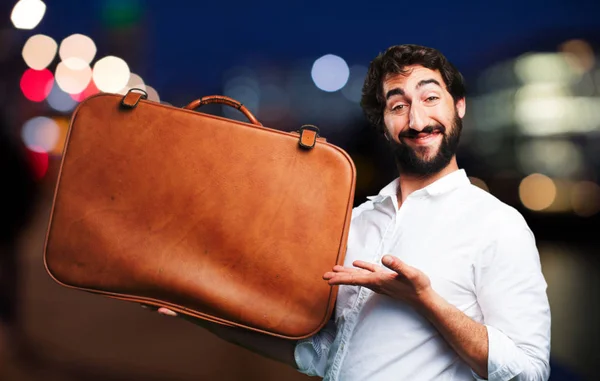 Молодой смешной человек с туристическим чемоданом — стоковое фото