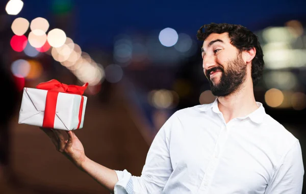 Junger lustiger Mann mit einem Geschenk — Stockfoto