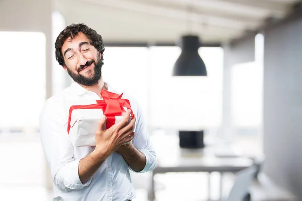 Junger lustiger Mann mit einem Geschenk — Stockfoto