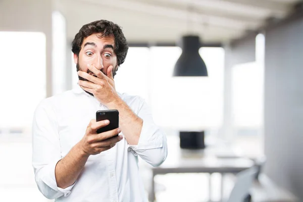 Hombre con teléfono móvil y expresión sorpresa —  Fotos de Stock