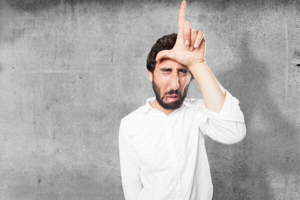 man with loser sign and sad expression