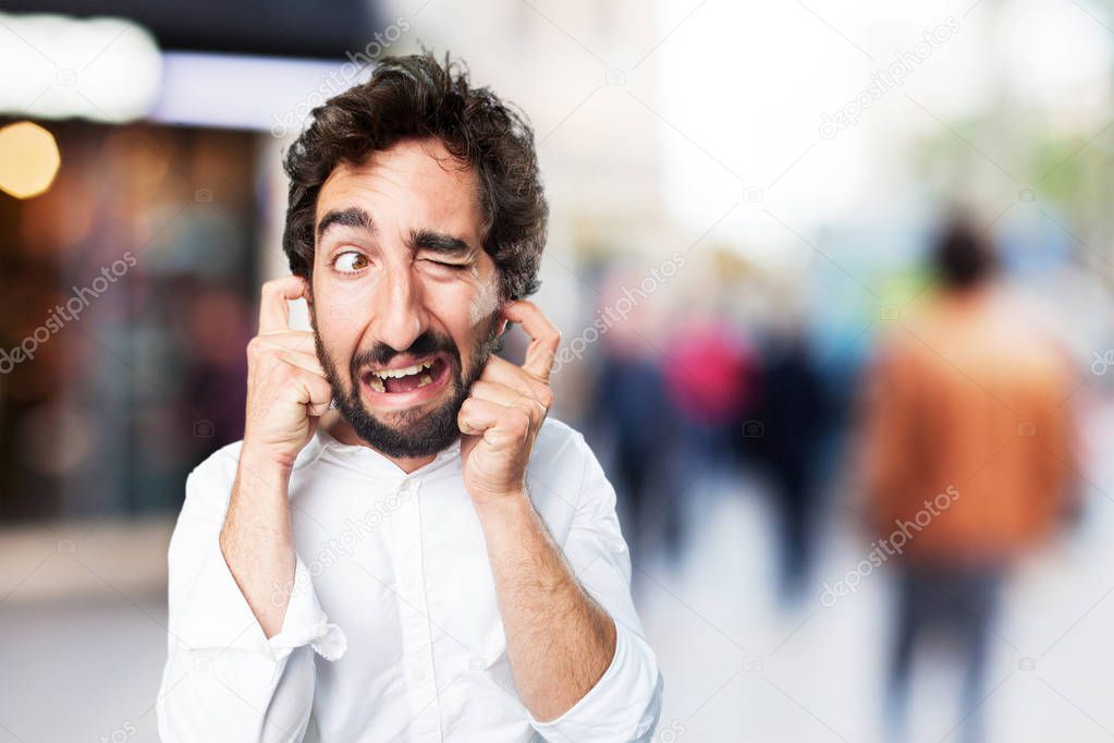 man covering ears with disagree expression