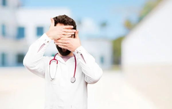 Mladý lékař muž krycí oči — Stock fotografie