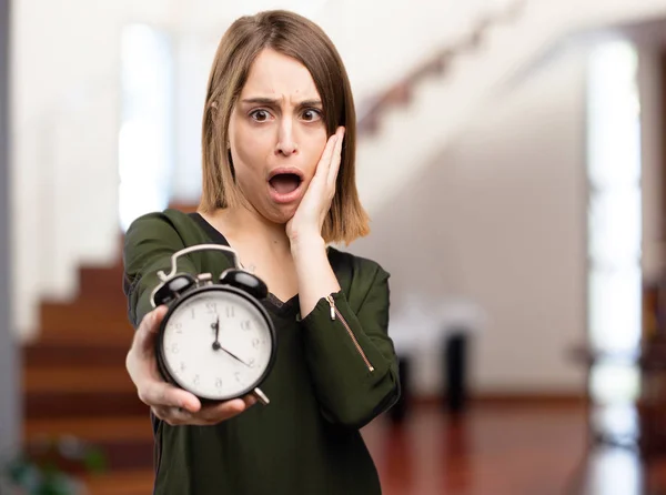 Surprised pretty woman with a clock — Stock Photo, Image