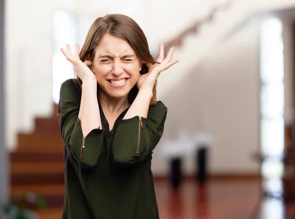 Wütende hübsche Frau, die die Ohren bedeckt — Stockfoto