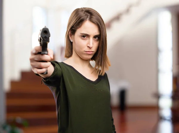 Сердитая симпатичная женщина с пистолетом — стоковое фото
