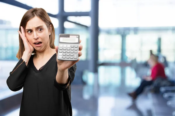 Mujer bonita sorprendida con una calculadora —  Fotos de Stock