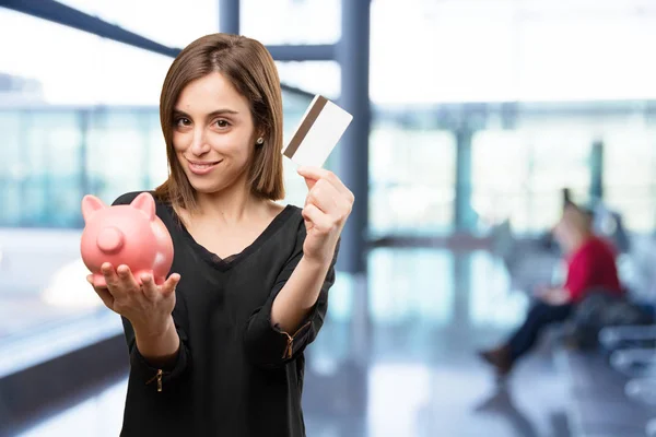 Mujer con tarjeta de crédito y hucha — Foto de Stock