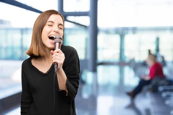 Jeune jolie femme avec un microphone — Photo