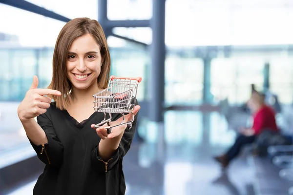 Junge hübsche Frau mit Einkaufswagen — Stockfoto