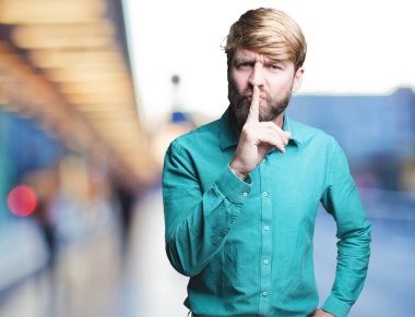 Genç sarışın adam sessizlik işareti ile 