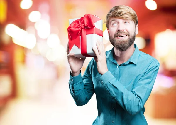 Young blonde man with a gift — Stock Photo, Image