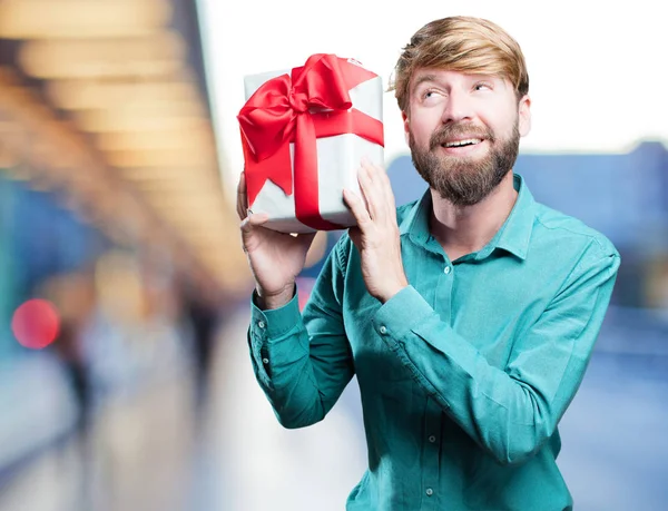 Young blonde man with a gift — Stock Photo, Image