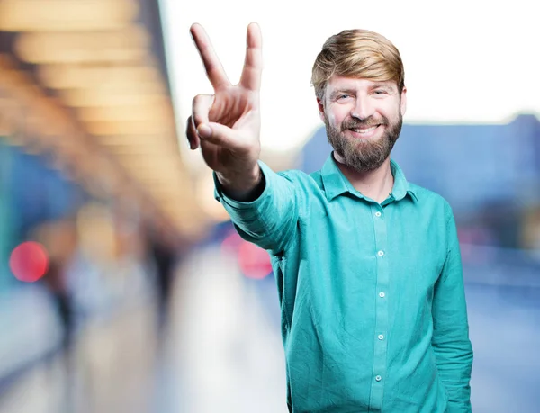 Junger blonder Mann mit Siegeszeichen — Stockfoto