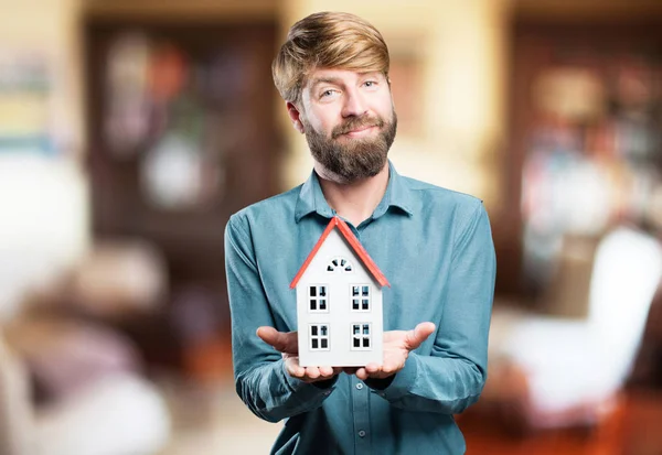 Blonde jongeman met een huis — Stockfoto