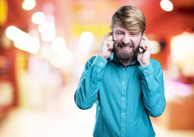 Adam kulaklarını kapatıyor.