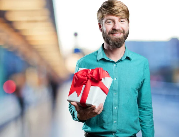 Young blonde man with a gift — Stock Photo, Image