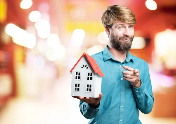 Junger blonder Mann mit einem Haus — Stockfoto