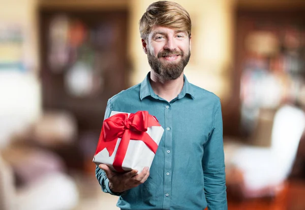 Blonde jongeman met een gift — Stockfoto