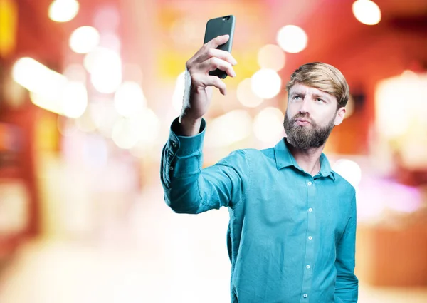 Jeune homme blond avec téléphone portable — Photo