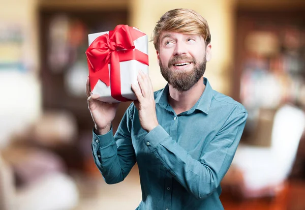 Young blonde man with a gift — Stock Photo, Image