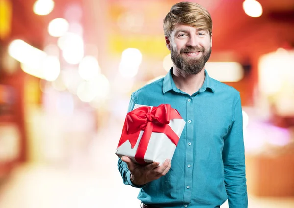 Blonde jongeman met een gift — Stockfoto