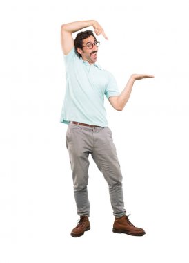 Boş bir yer için senin konseptin gösterilen genç deli adam. Tam vücut kesme kişi beyaz arka plan.