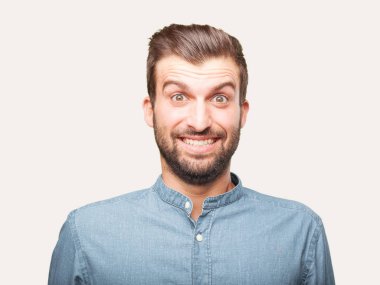 Yakışıklı delikanlı sürpriz veya mavi t gömlek giymiş ifade şok. Mutlu kavramı. Tek renkli arka planı izole kişi.