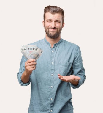 Genç yakışıklı adam, mavi kot gömlek, 20 Euro banknot, memnun ve başarısını kutluyor. para kavramı. Tek renkli arka planı izole kişi.