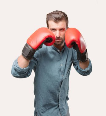 Genç yakışıklı boks kırmızı eldiven mavi kot gömlek giymiş adam. Tek renkli arka planı izole kişi.