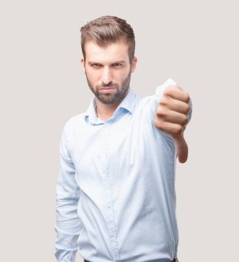 Yakışıklı delikanlı katılmıyorum ve kızgın ifade bir mavi t gömlek giymiş. Tek renkli arka planı izole kişi.