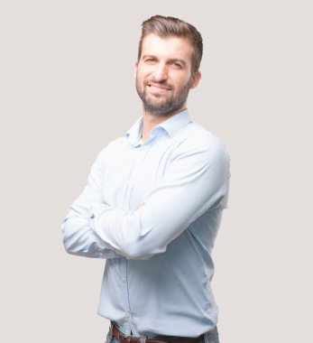 Yakışıklı delikanlı ile gurur ya da mutlu ifade bir mavi t gömlek giymiş. Tek renkli arka planı izole kişi.
