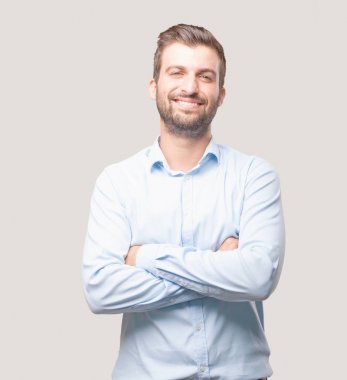 Yakışıklı delikanlı ile gurur ya da mutlu ifade bir mavi t gömlek giymiş. Tek renkli arka planı izole kişi.