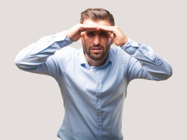 Genç yakışıklı görünümlü çok giyiyor mavi tişörtlü adam. Tek renkli arka planı izole kişi.