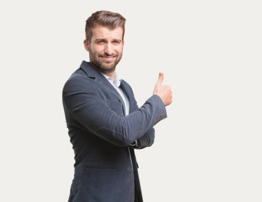Tüm doğru işaret, mavi ceket, mutlu ifade ile genç yakışıklı işadamı. Tek renkli arka planı izole kişi.