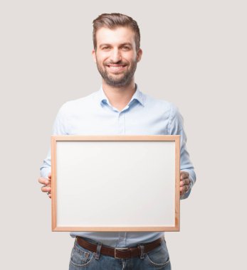 Kavramı, mavi tişörtlü, mutlu ifade yerleştirmek için boş bir afişini tutan genç yakışıklı adam. Tek renkli arka planı izole kişi.