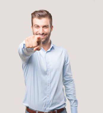 Genç yakışıklı işaretleme açık mavi t gömlek giymiş adam. Tek renkli arka planı izole kişi.