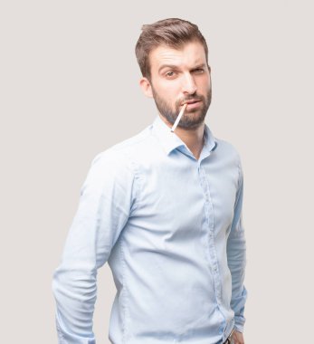 Genç yakışıklı mavi t gömlek giymiş Sigara İçilmeyen adam. Tek renkli arka planı izole kişi.