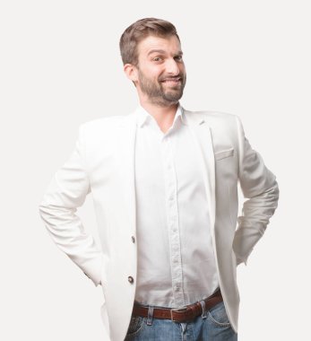 genç yakışıklı işadamı bakan bir meydan okuma poz, beyaz ceket, mutlu ifade. Tek renkli arka planı izole kişi.