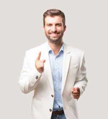 genç yakışıklı işadamı dans, beyaz ceket, mutlu ya da memnun ifade. Tek renkli arka planı izole kişi.