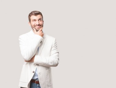 genç yakışıklı işadamı düşünme veya şüphe, beyaz ceket ve memnun ya da mutlu ifade. Tek renkli arka planı izole kişi.