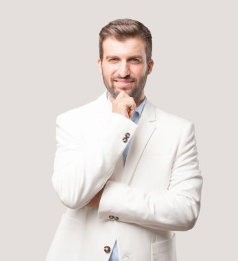 genç yakışıklı işadamı düşünme veya şüphe, beyaz ceket ve memnun ya da mutlu ifade. Tek renkli arka planı izole kişi.