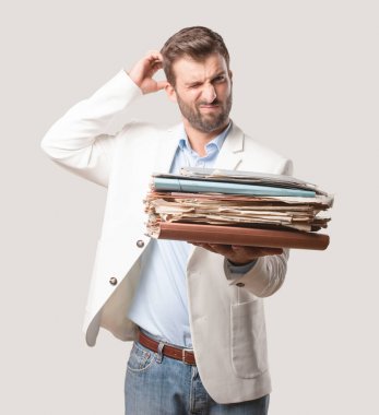 young handsome businessman holding files or a weitht documents tower, white blazer, and bored or disagree expression. Person isolated against monochrome background. clipart